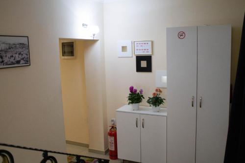a hospital room with a white cabinet and flowers at Hotel Living in Šuto Orizari