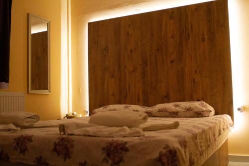 a bedroom with two beds and a wooden headboard at Hotel Living in Šuto Orizari