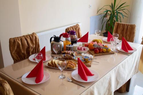 a table topped with plates of food and wine glasses at Hotel Living in Šuto Orizari