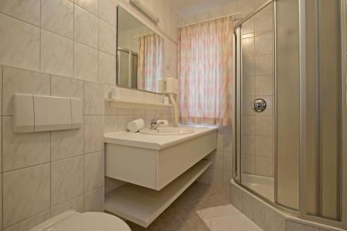 ein Bad mit einem Waschbecken, einem WC und einer Dusche in der Unterkunft Tirolerhaus in Walchsee