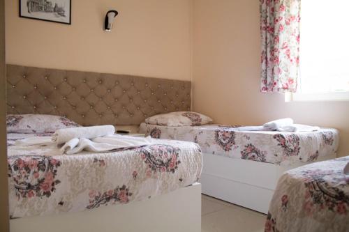 a room with two twin beds and a window at Hotel Living in Šuto Orizari