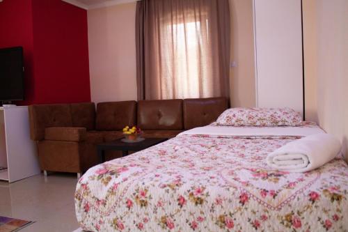 a bedroom with a bed and a couch at Hotel Living in Šuto Orizari