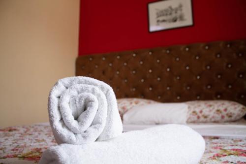 a pile of towels sitting on top of a bed at Hotel Living in Šuto Orizari
