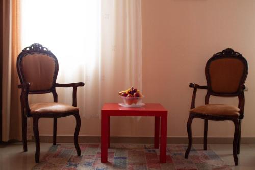 two chairs and a table with a bowl of fruit at Hotel Living in Šuto Orizari
