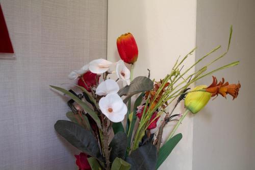a bouquet of flowers in a vase on a wall at Hotel Living in Šuto Orizari