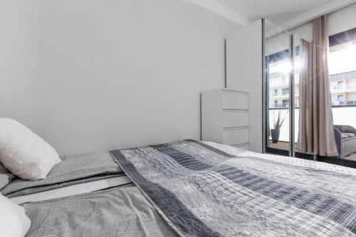 Tempat tidur dalam kamar di Apartament MILAN Gardenia Dziwnów z widokiem na morze EPapartamenty