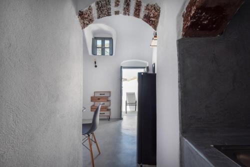 a hallway with a table and a chair in a room at Noelia Suites in Oia