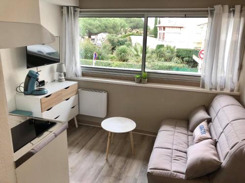 a small living room with a couch and a window at Studio Arcachon vue mer en hyper centre in Arcachon