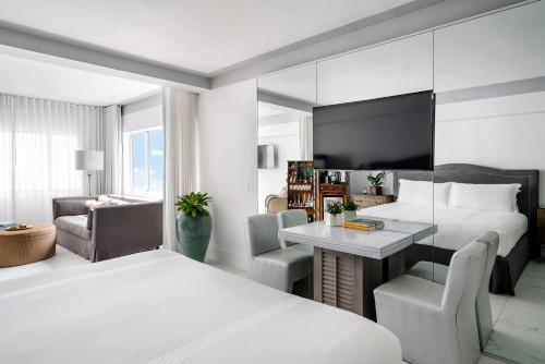 a hotel room with two beds and a desk at Nautilus Sonesta Miami Beach in Miami Beach