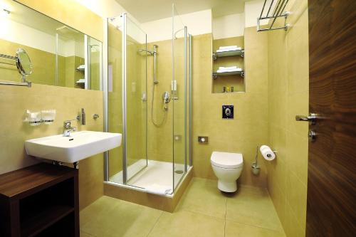 a bathroom with a shower and a sink and a toilet at Hotel Biograf in Písek