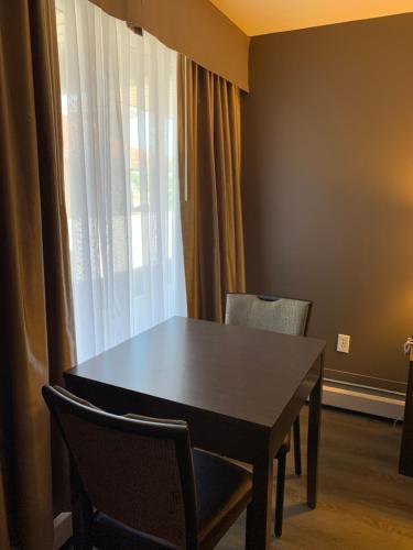 a dining room table with chairs and a window at Econo Lodge Inn & Suites in Lethbridge