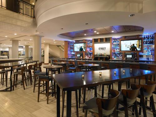 un restaurante con mesas, sillas y TV en Hyatt Regency Rochester, en Rochester