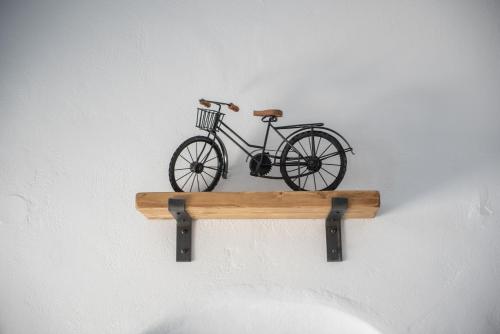 a bike on a wooden shelf on a wall at Noelia Suites in Oia