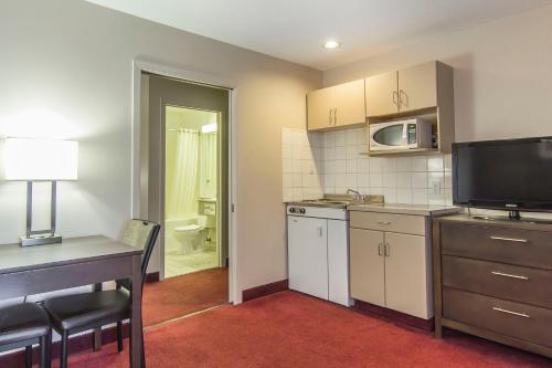 a small kitchen with a table and a microwave at Econo Lodge Inn & Suites in Lethbridge