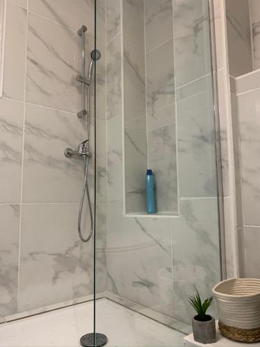 une salle de bain avec une douche avec une porte vitrée dans l'établissement AZUR, à Saint-Nazaire