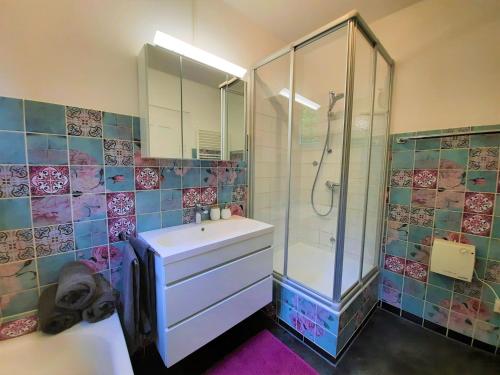 a bathroom with a shower and a sink and a glass shower stall at FeWo Forstvilla Beuron in Beuron