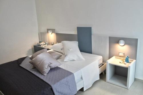 una piccola camera da letto con un letto e un comodino di GIOANTHONY a Porto Cesareo