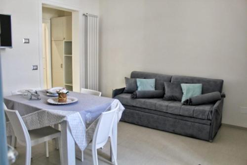 un soggiorno con un tavolo e un divano di GIOANTHONY a Porto Cesareo