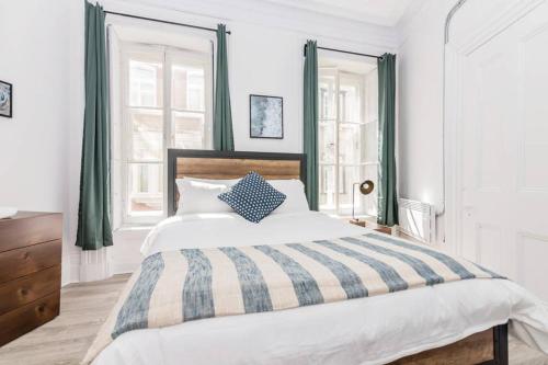 a bedroom with a bed with a blue and white comforter at Manoir des Remparts- Renovated 3 Bedroom Oasis in Quebec City