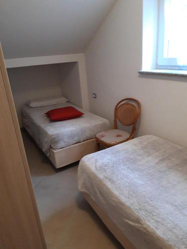 um pequeno quarto com 2 camas e uma janela em Appartamento em Commezzadura