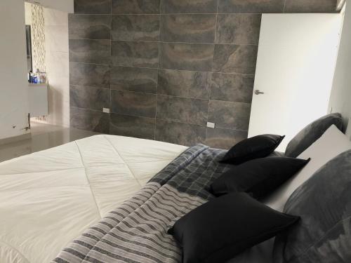 una cama con almohadas negras en una habitación en Villa Nova Condominio en La Plata