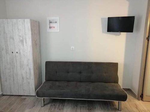 a couch sitting in a living room with a tv at Ethra luxury studios in Asprovalta