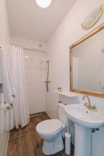 a white bathroom with a toilet and a sink at Zwierzyńscy Residence 2 in Pobierowo