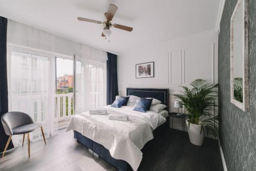 a bedroom with a bed and a ceiling fan at Zwierzyńscy Residence 2 in Pobierowo