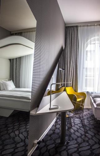 a hotel room with a bed and a table and a yellow chair at Magic Hotel Korskirken in Bergen