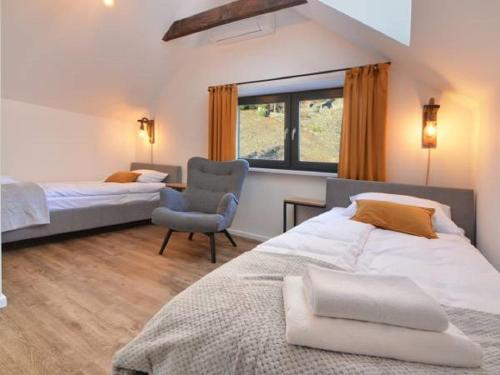 um quarto com 2 camas, uma cadeira e uma janela em Apartament Marron 12 z sauną, bawialnią i widokiem na Skrzyczne - Dream Apart em Szczyrk