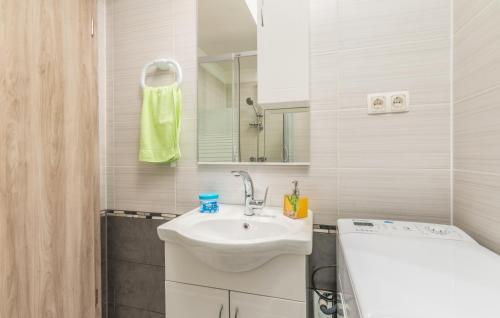 a white bathroom with a sink and a mirror at Apartments Mioković in Soline