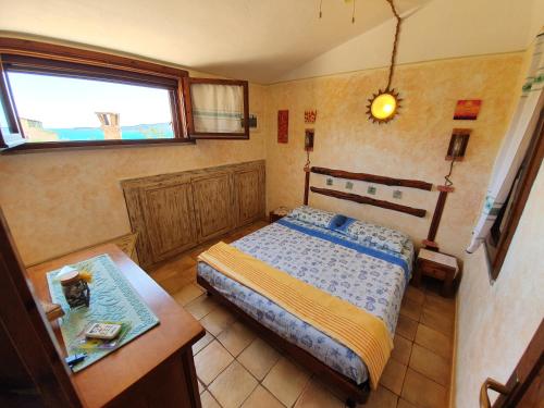 ヴィッラシミーウスにあるCasa Soleのベッドルーム1室(ベッド1台、テーブル、窓付)