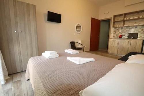 a bedroom with two beds with towels on top of it at Ethra luxury studios in Asprovalta