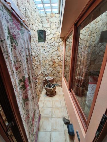 a bathroom with a window and a stone wall at Casa Sole in Villasimius