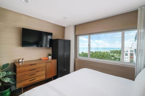 a bedroom with a bed and a tv and a window at Nautilus Sonesta Miami Beach in Miami Beach