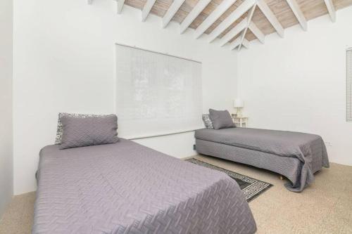 Una cama o camas en una habitación de Beachfront White Palm Villa- Tar Bay, Great Exuma