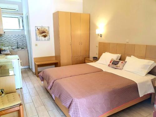 une chambre avec un grand lit et une cuisine dans l'établissement Daglas Seaside Studios, à Nydri