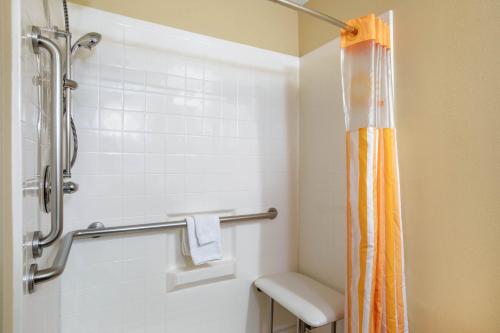 a bathroom with a shower with an orange shower curtain at La Quinta by Wyndham Conway in Conway