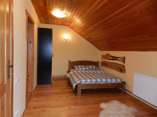 a bedroom with a bed and a wooden ceiling at Cabana Festung in Bran