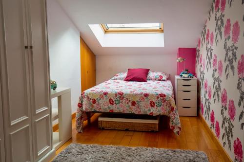 um pequeno quarto com uma cama e uma janela em Duplex con encanto en Cimadevilla em Gijón