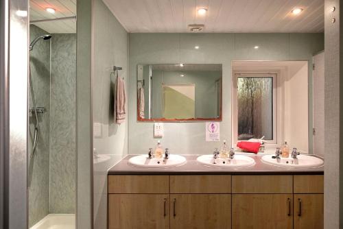 a bathroom with two sinks and a shower at Loch Ness Backpackers Lodge in Drumnadrochit