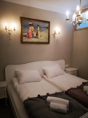 a bedroom with two beds and a painting on the wall at Romantyczny Apartament HAPPY 16 BASEN & KORT TENISOWY, OCHRONA 24 h - dla maksymalnie 6 osób in Pobierowo