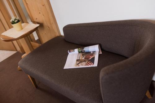 a magazine sitting on the arm of a chair at Hotel & Residence Rebhof in Tirolo