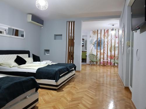 a bedroom with two beds and a wooden floor at Hotel Villa Nadin in Mostar