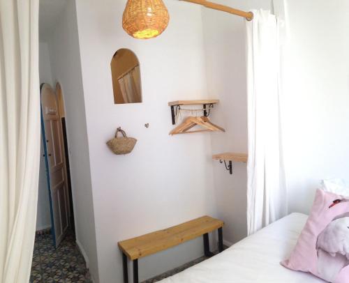 a room with a bed and a wooden bench at Hôtel Emeraude Essaouira in Essaouira