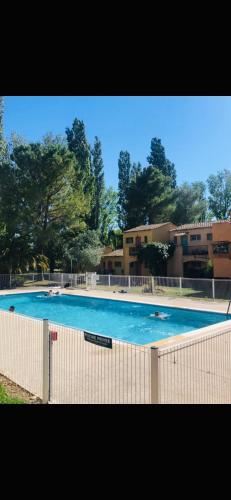 une grande piscine bleue devant un immeuble dans l'établissement Appartement village 9 en résidence de vacances en Camargue, à Arles