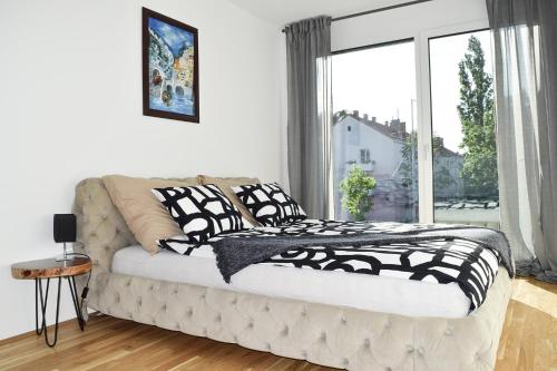 um quarto com uma cama e uma grande janela em Cosy new Apartment 3min to VIC/Uno-City and Danube em Viena
