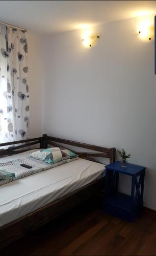 a bedroom with a bed and a blue night stand at Complex Alena in Ranca