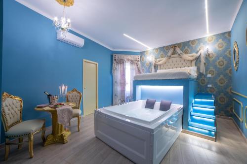 a blue bedroom with a bed and a bath tub at Love Suite Roma - Il Nido d'Amore in Rome