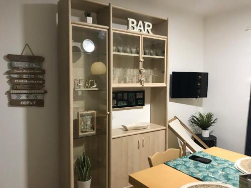 une salle à manger avec une table et un panneau de bar dans l'établissement Charmant appartement au cœur de Juan les Pins, à Antibes